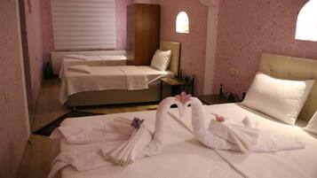 Quarto de hotel com duas camas, uma janela e um radiador.