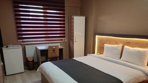 Una camera da letto con un letto, una scrivania e un armadio.