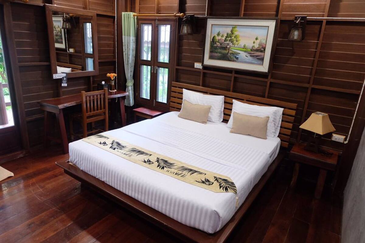 A wooden-framed bedroom with a bed, a desk, and a chair.