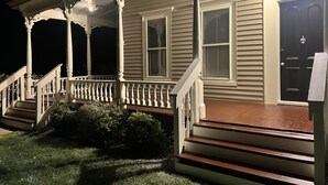 A house with a porch, a front door, and a staircase leading to the entrance.