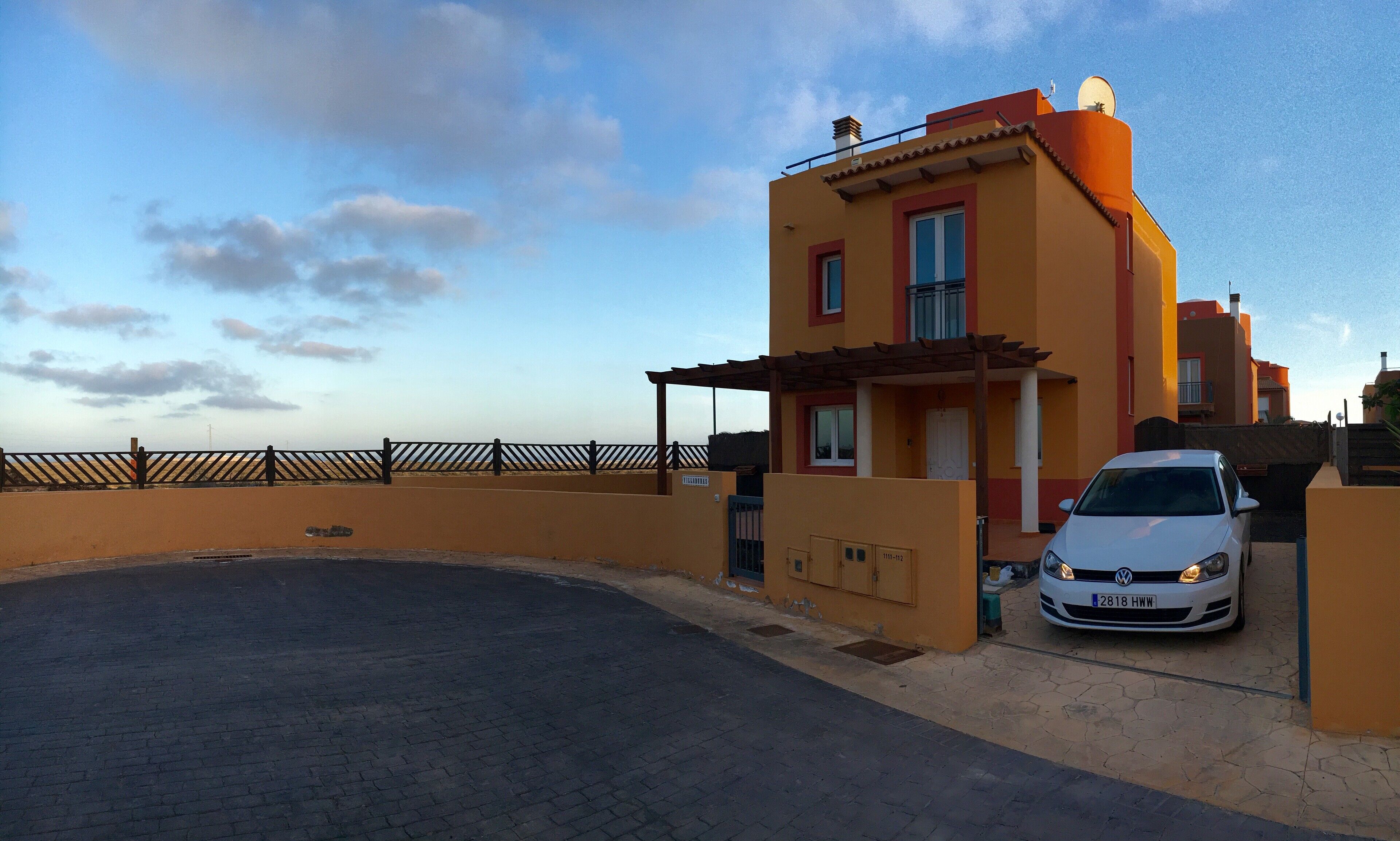 Un edifici residencial amb un cotxe a la façana.