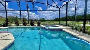 Una piscina con acqua cristallina e trasparente, circondata da una zona coperta con struttura in metallo e pannelli di vetro.