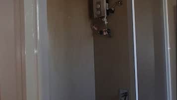 A bathroom with a shower, a toilet, and a sink.