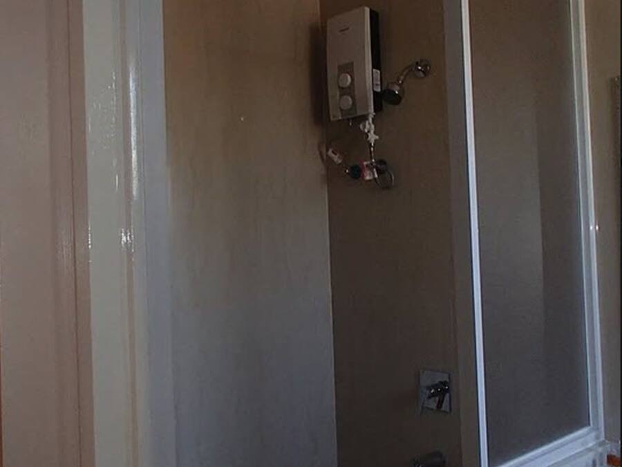 A bathroom with a shower, a toilet, and a sink.
