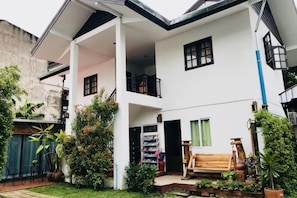 A two-story house with a balcony, a staircase, and a garden area. - Kitti Rose Home (Chiang Mai)