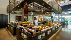 A buffet area with a variety of food items and a chef standing behind the counter. - Grandvrio Ocean Resort Danang (Da Nang)