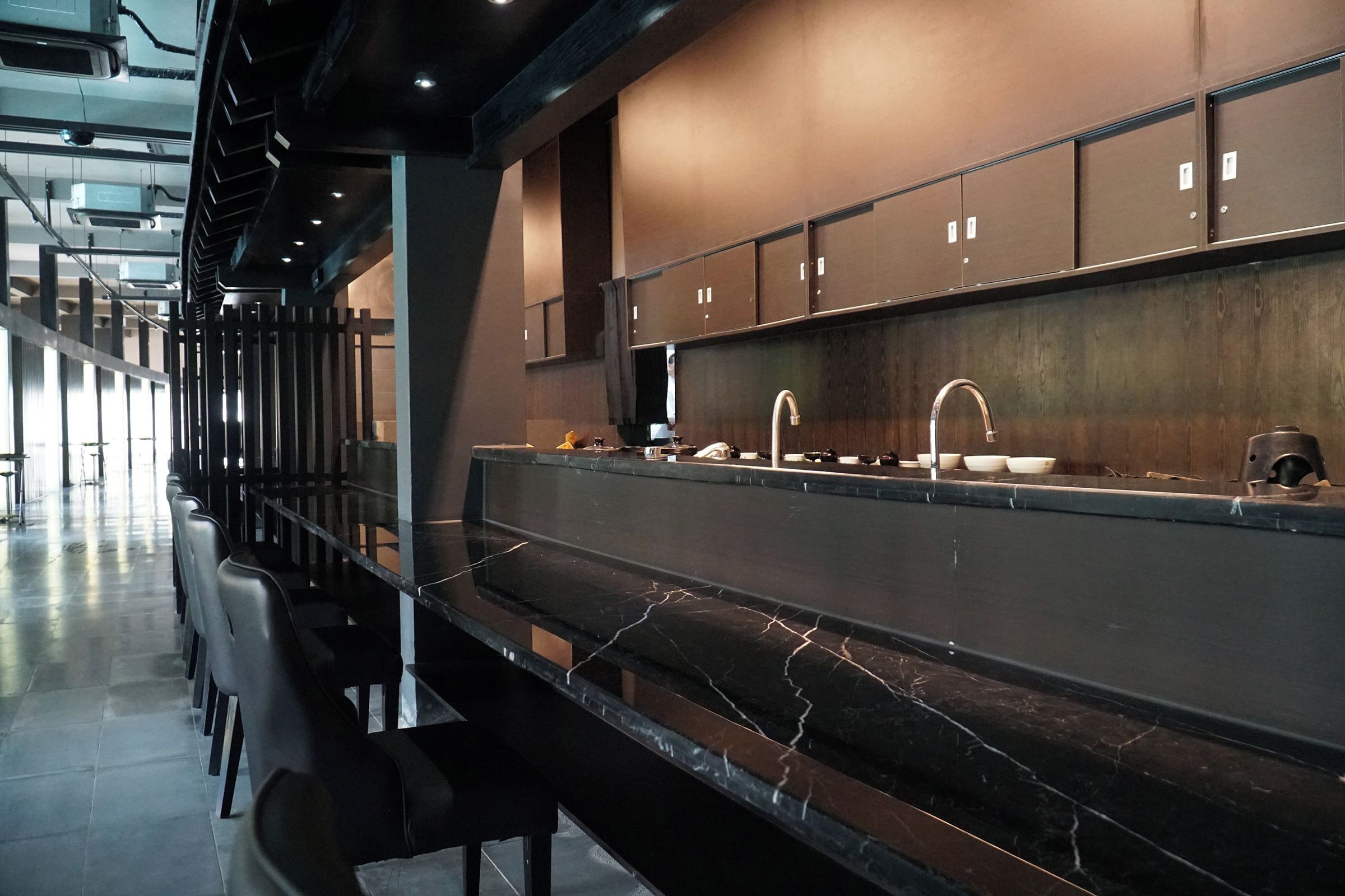A modern kitchen with a marble countertop, stainless steel appliances, and a built-in oven.