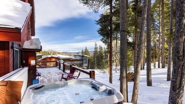 A hot tub on a wooden deck with snow-covered ground and trees in the background. - Secluded Getaway: Private Hot Tub & Forest Views (Breckenridge)