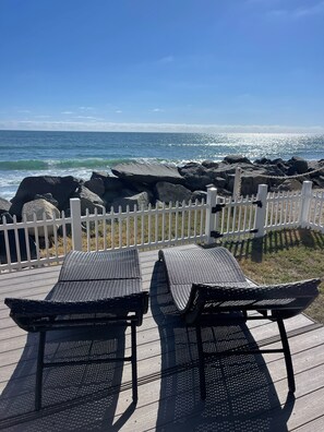 A deck with two black wicker chairs facing a rocky coastline and ocean. - Entire Beachfront Home W/ SPA & Private Large Backyard!!! (Oceanside)