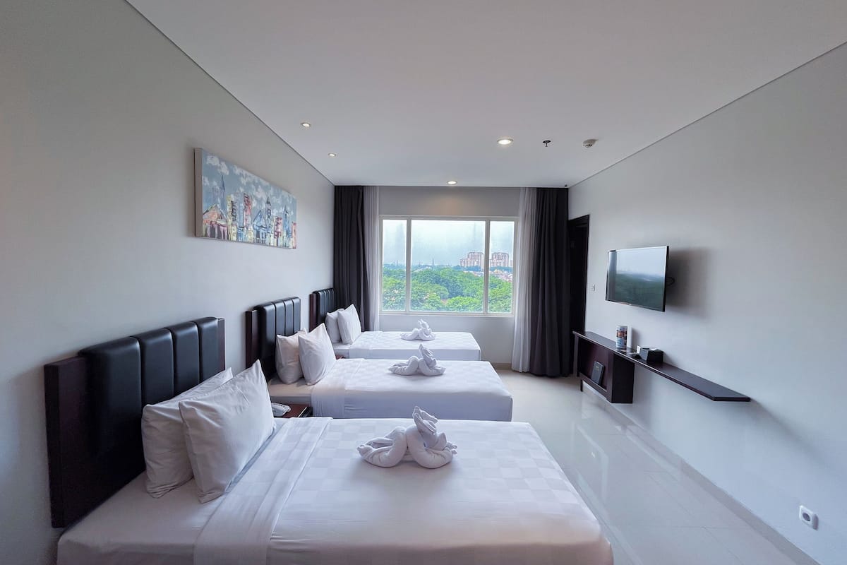 A hotel room with two beds, a flat-screen TV, a painting, and a city view.