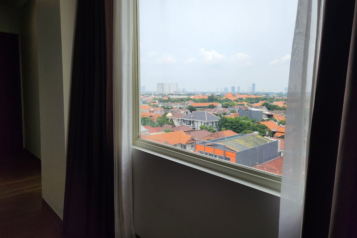 A window view of a residential area with buildings and a clear sky.