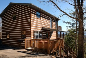 A log cabin with a wooden deck and a staircase leading to a balcony. - Great Mountain View | Next to Dollywood | Pool Table | Pet Friendly | Hot Tub (Pigeon Forge)