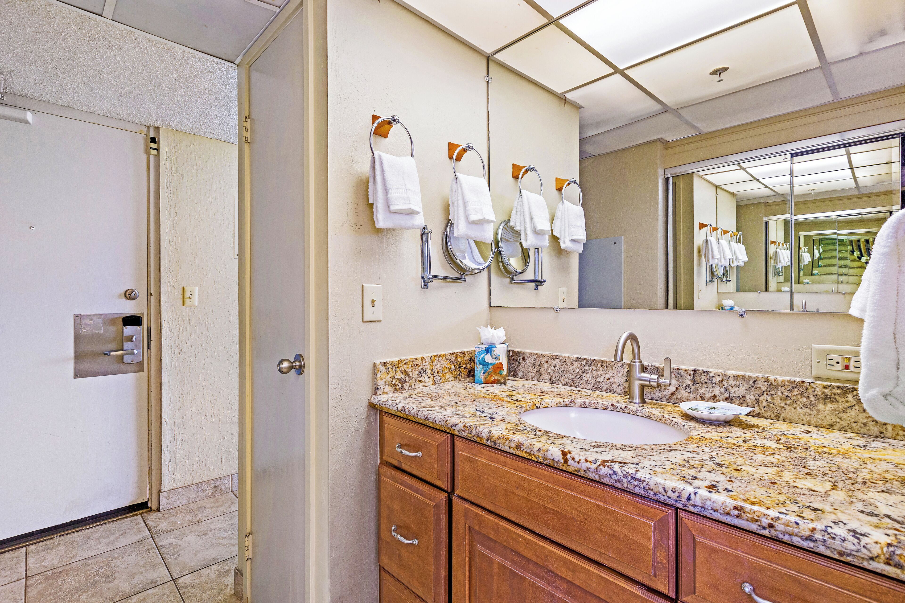 A bathroom with two sinks, a mirror, and a towel rack.