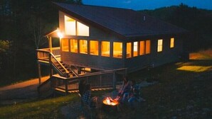 Una casa a due piani con una terrazza e un braciere.