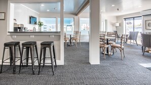 A modern interior with a bar area, seating, and a view of the outside.