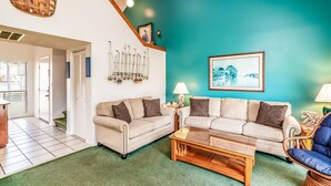 A living room with two sofas, a coffee table, a lamp, and a wall-mounted sailboat decoration. - Heron Marsh 86 in Litchfield By the Sea, steps away from the pool and beach (Pawleys Island)