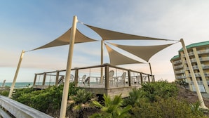 A beachside gazebo with a wooden deck and outdoor seating, overlooking the ocean. - Heron Marsh 86 in Litchfield By the Sea, steps away from the pool and beach (Pawleys Island)