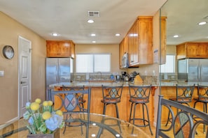 Enjoy cooking in this well-equipped kitchen with a central island, refrigerator, microwave, and sink.