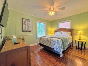 A bedroom with a bed, a desk, a chair, a ceiling fan, and two windows. - 213 Ohio Cozy Cottage Just Short Walk to Beach (Fort Myers Beach)