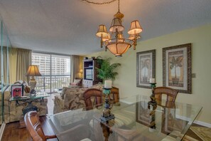 Enjoy a meal at the glass-top table surrounded by comfortable seating and a large window offering a view of the city.