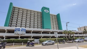 Un hotel con un grande cartello che riporta 'Royal Garden Resort' e un parcheggio sottostante.