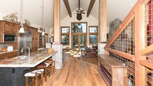 A spacious kitchen with high ceilings, wooden beams, and large windows offering views of the outdoors. - Overlook Lake View Lodge by Tahoe Getaways- Dog Friendly, HOA, Donner Lake Views + Hot Tub (Truckee)