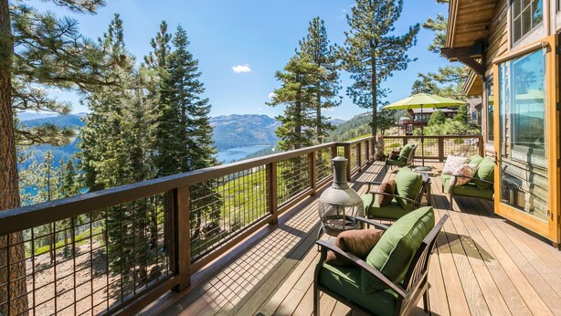 A wooden deck with outdoor seating, a view of a lake and mountains, and a glass door leading to a room. - Overlook Lake View Lodge by Tahoe Getaways- Dog Friendly, HOA, Donner Lake Views + Hot Tub (Truckee)
