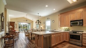 Una cocina amplia con armarios de madera, una isla central y electrodomésticos modernos.