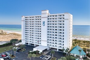 Un hôtel de grande hauteur, doté d’un logo bien visible, d’un parking et offrant une vue sur la plage.