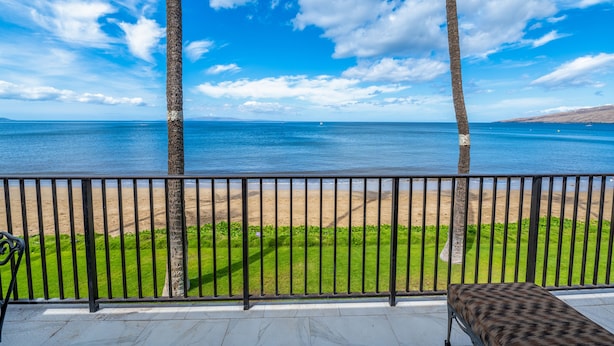 Ein Balkon mit Blick auf Strand und Meer.