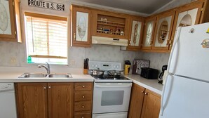A kitchen with wooden cabinets, a white stove, and a refrigerator.