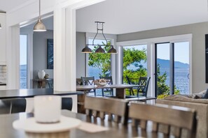 Eine moderne Küche mit Essbereich, großen Fenstern und Meerblick.