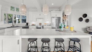 A modern kitchen with a large island, stainless steel appliances, and pendant lighting. - Incredible, completely renovated oceanfront villa (Kiawah Island)