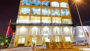A tall hotel with multiple floors, large windows, and a well-lit facade. - Fivitel Da Nang (Da Nang)