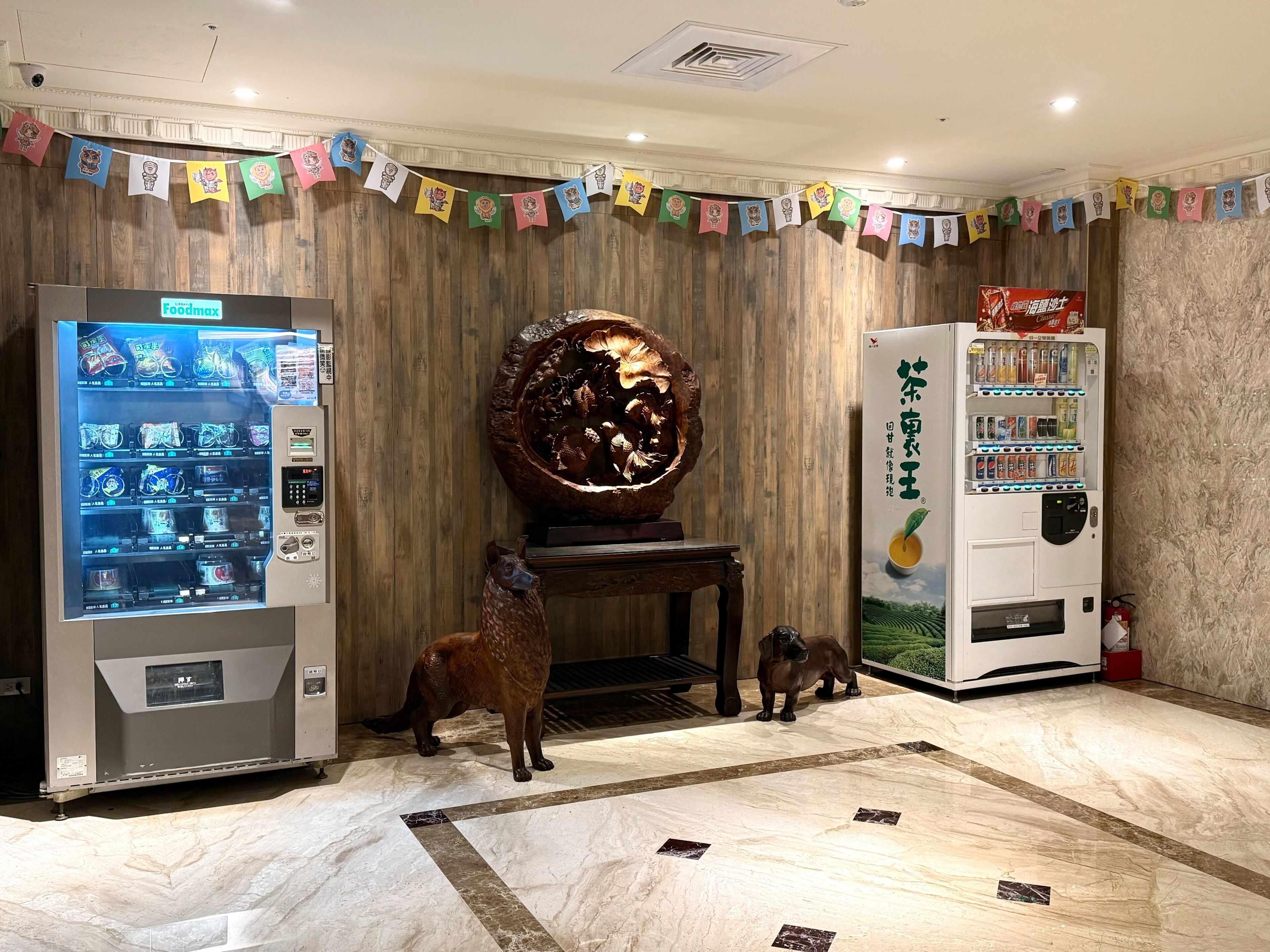A vending machine area with a large decorative piece and a wooden wall.