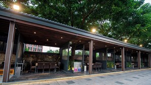 En udendørs overdækket terrasse med siddepladser og en automat.