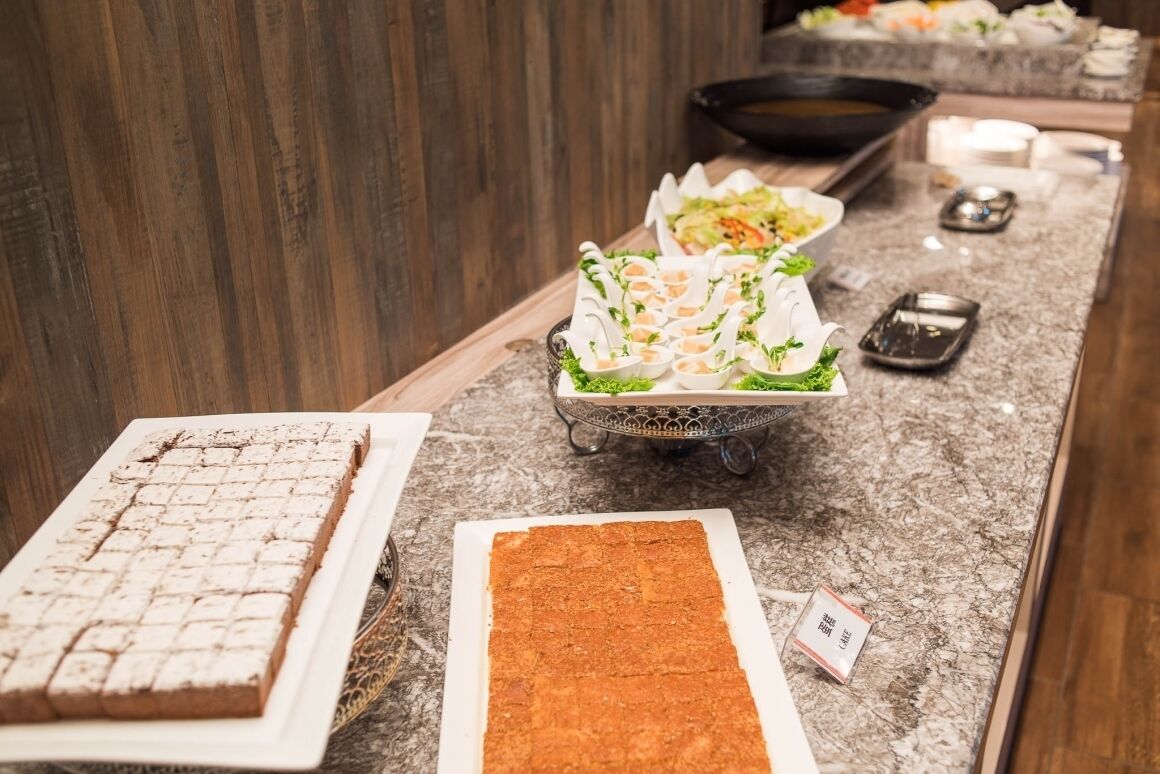 A buffet setup with various dishes and a dessert bar.