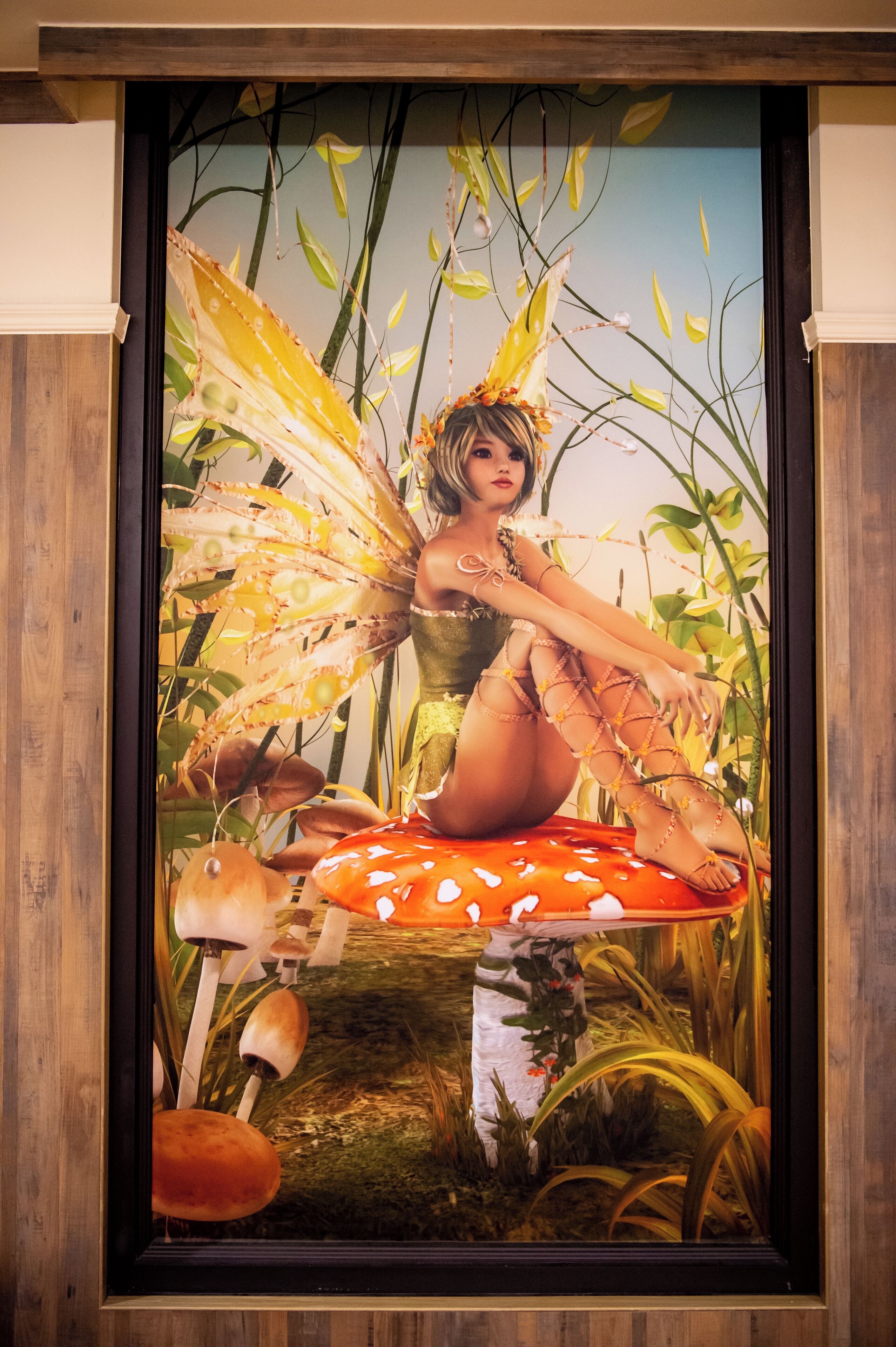 Obra de arte enmarco que muestra a un hada sentada sobre un hongo, con un bosque de fondo.