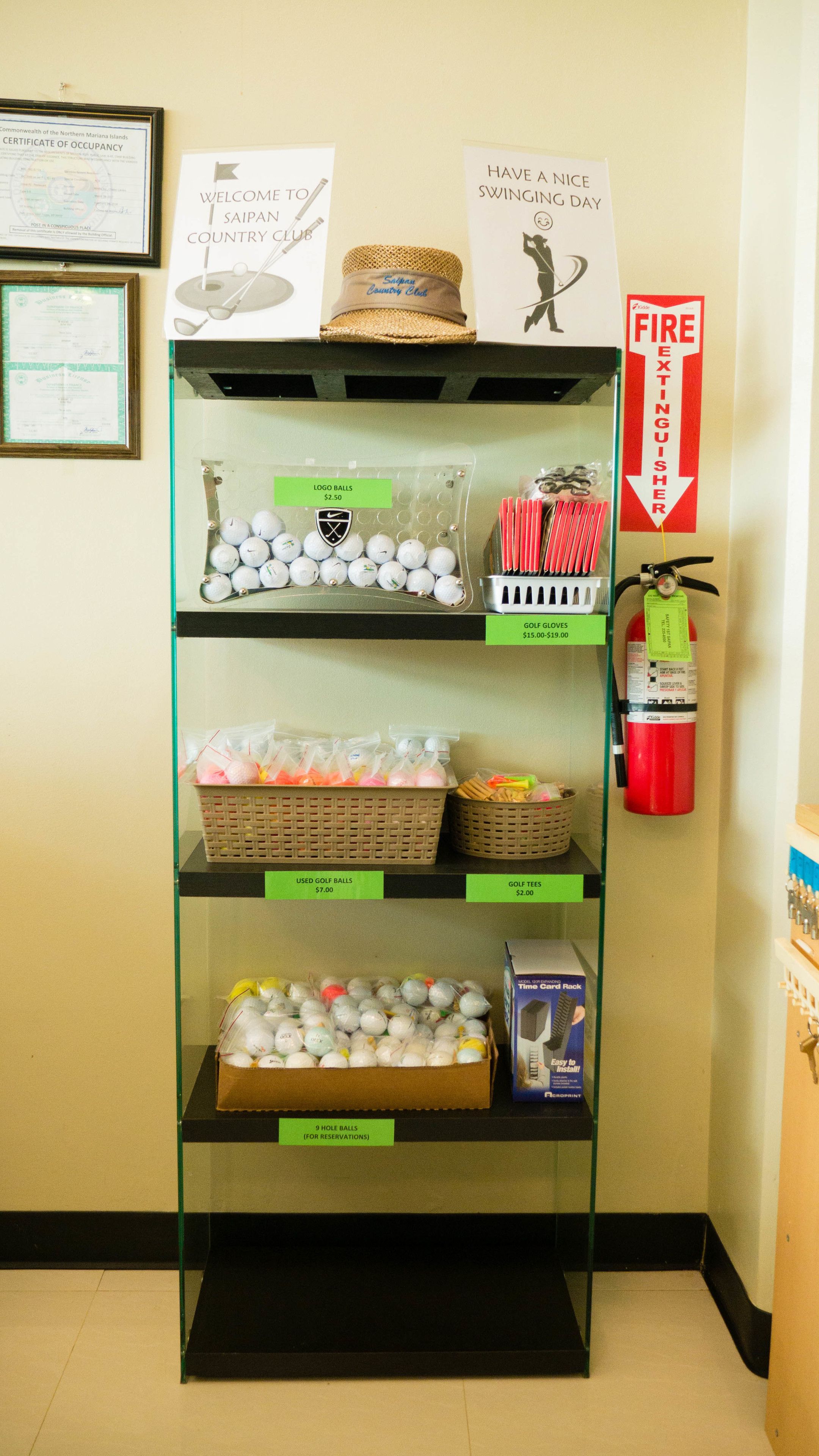 A display of golf-related items including golf balls, gloves, and tees, with price tags visible.