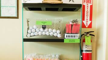 Exhibición de artículos relacionados con el golf, incluyendo pelotas, guantes y tees, con etiquetas de precio a la vista.