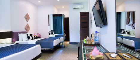 A hotel room with two beds, a TV, a mirror, and a small table with toiletries.