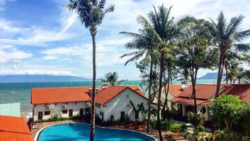 A resort with a swimming pool, palm trees, and ocean views.