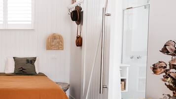 A bedroom with a bed, a wooden table, a chair, and a wardrobe with a sliding door.