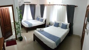 A hotel room with two single beds, a large window with curtains, a potted plant, and a wooden door. - Nika's House (Siem Reap)