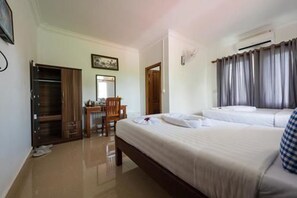 A hotel room with a bed, a desk, a chair, an air conditioning unit, and a wardrobe. - Nika's House (Siem Reap)