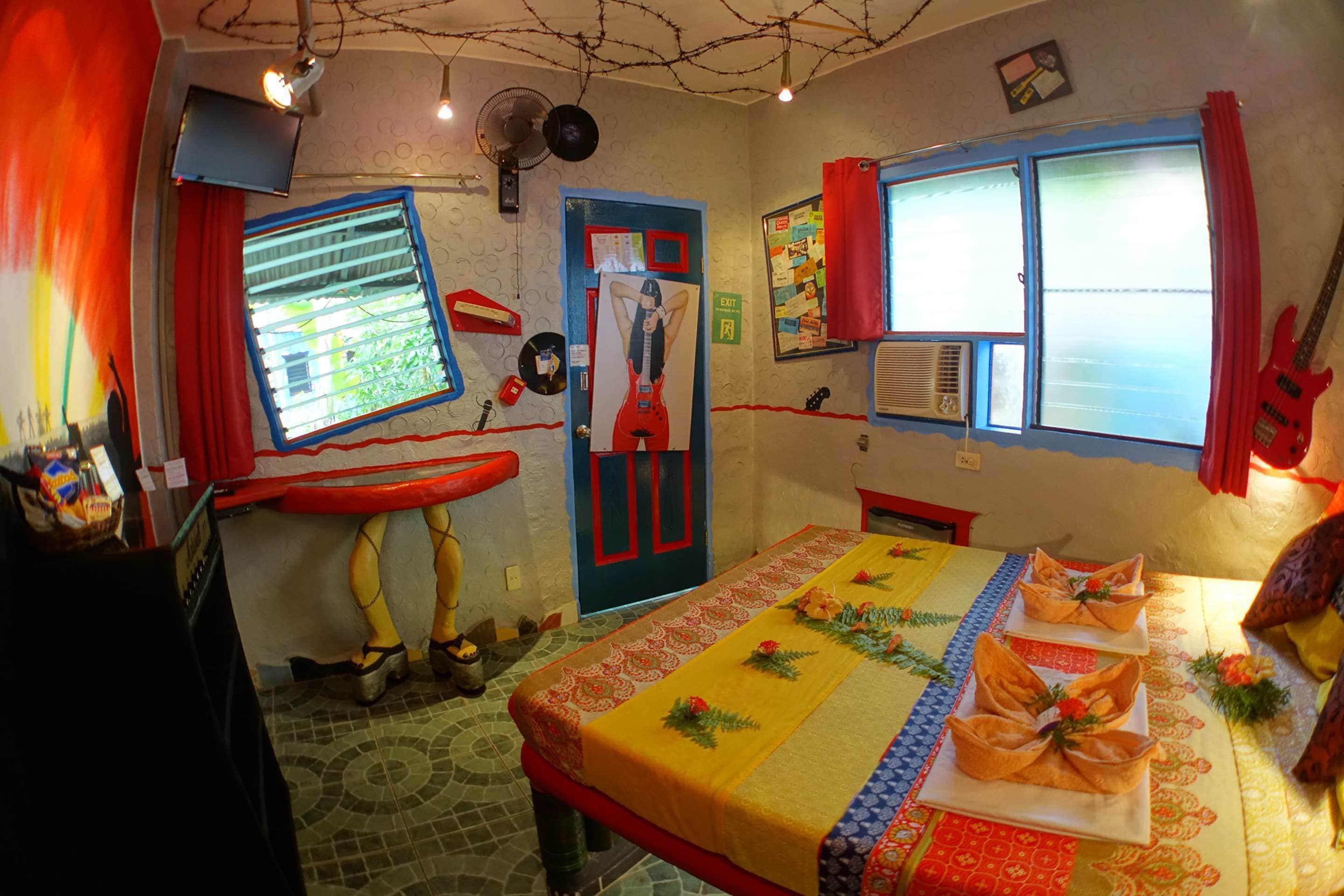 A room with a bed, a window with curtains, a guitar, and a wall with a poster.