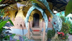 A rustic, cave-like structure with a wooden door, stone steps, and a thatched roof. - Takatuka Beach Resort (Sipalay)