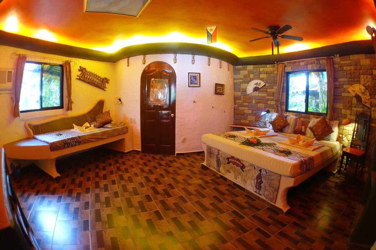 A room with a checkered wooden floor, a bed with a decorative headboard, a bench, and a door with a window.