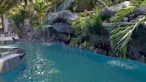 A pool with clear water, surrounded by rocks and plants. - Takatuka Beach Resort (Sipalay)