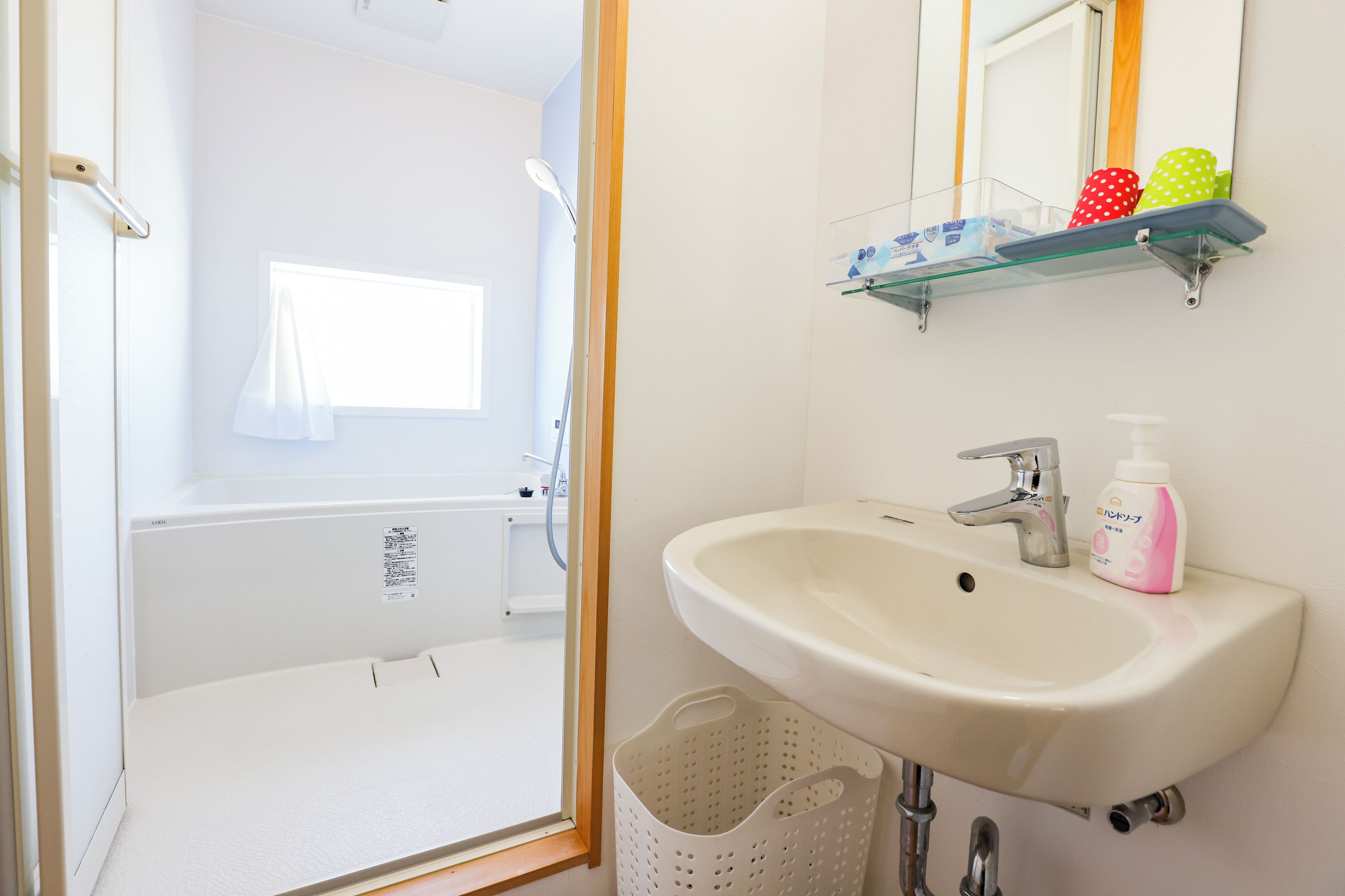 Een badkamer met een wastafel, spiegel en douche.